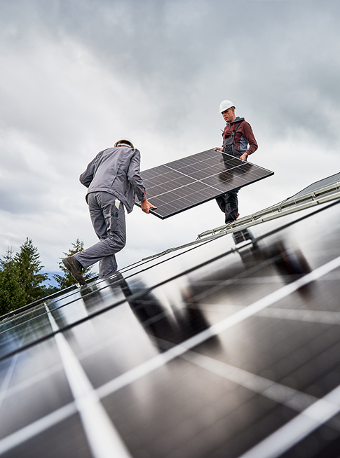 2 personnes déplacant un panneau photovoltaïque